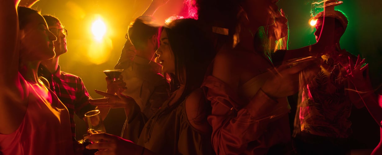En gruppe mennesker til en fest med farverige lys.