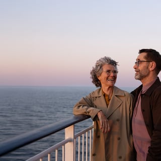 To personer står på dækket af et skib og kigger ud over havet.