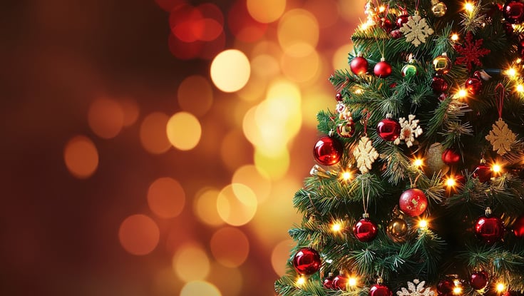 Pyntet juletræ med ornamenter og lys.