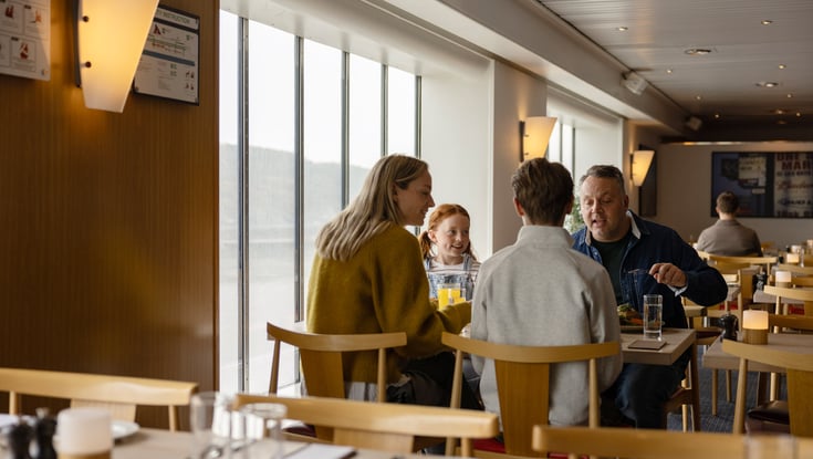 Gruppe af mennesker sidder ved et bord i en restaurant