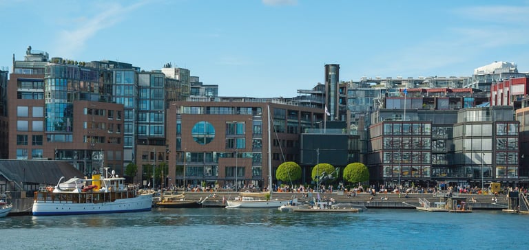 Vandkanten med moderne bygninger ved Aker Brygge.