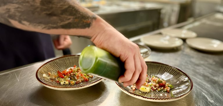 En kok der sætter mad på en tallerken