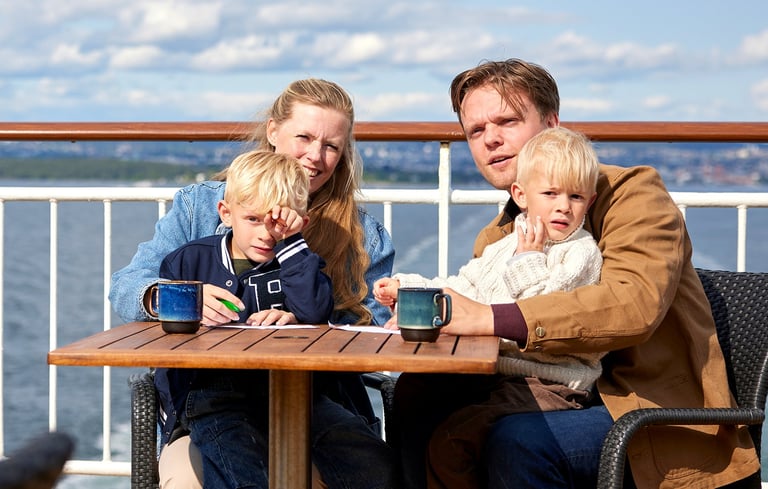 Familie nyder solen ude på dækket