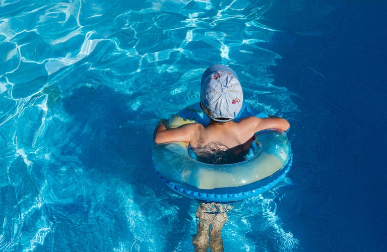 Dreng med badering i poolen